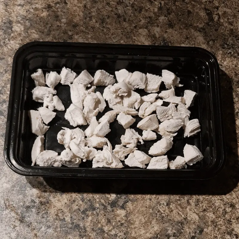 Cooked boiled Chicken pieces in black tray